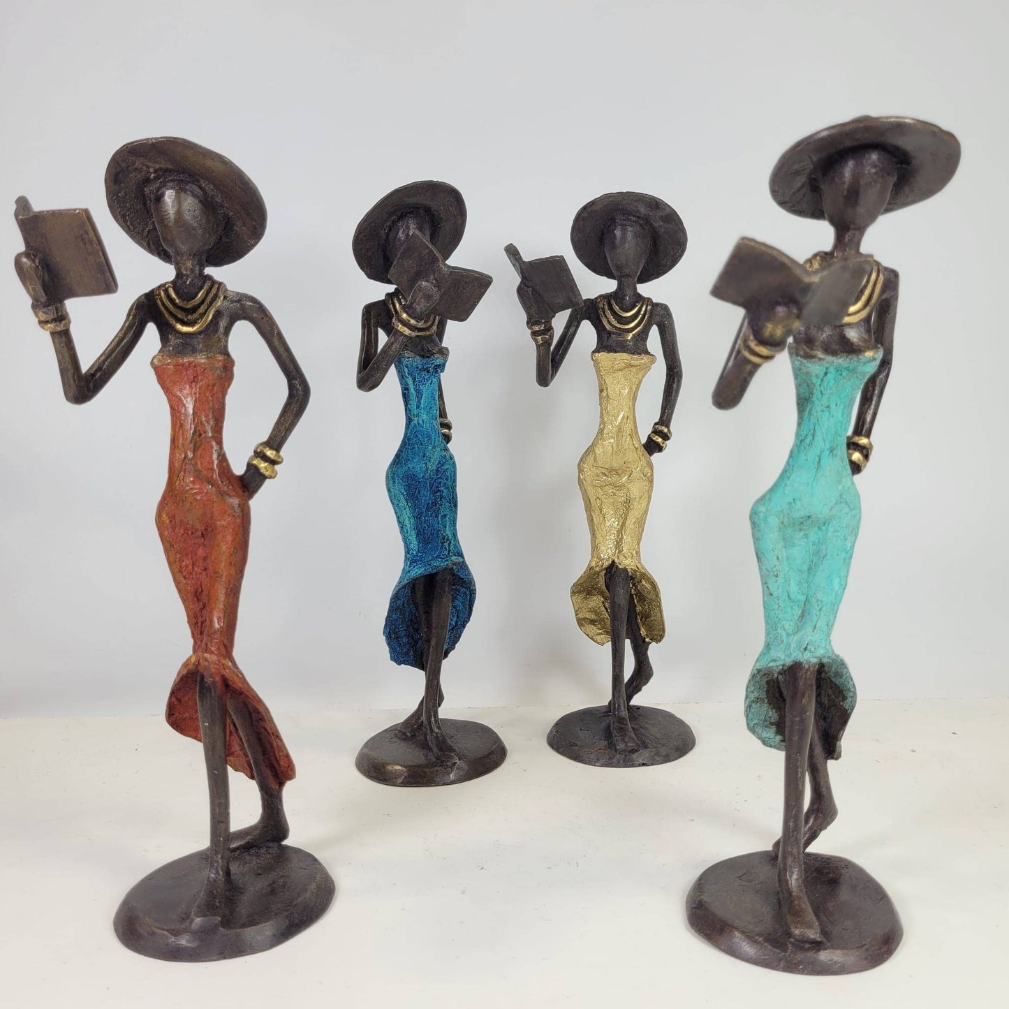 Kvinde med bog og hat – bronzeskulptur af den burkinske kunstner Soré, pastelgrøn kjole, str. 16 cm