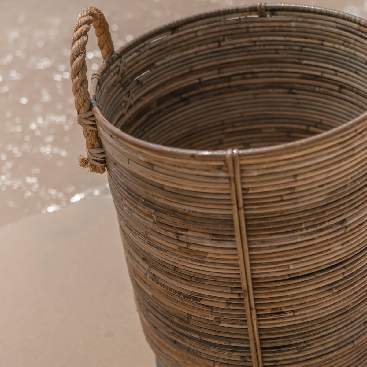 Nærbillede af rattan-kurv indeni med to håndtag og synlige fletlinjer.