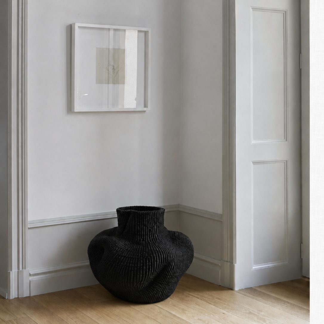 Sort kunst-kurv i lav, rund form med høj, snoet hals